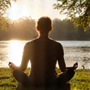 A person meditating peacefully outdoors.